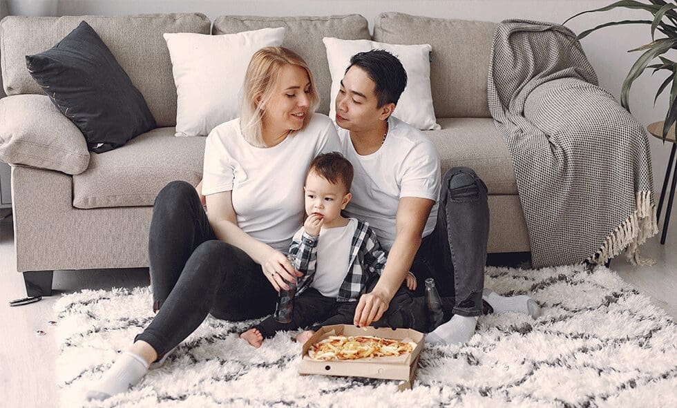 A man, woman and child sitting on the floor.