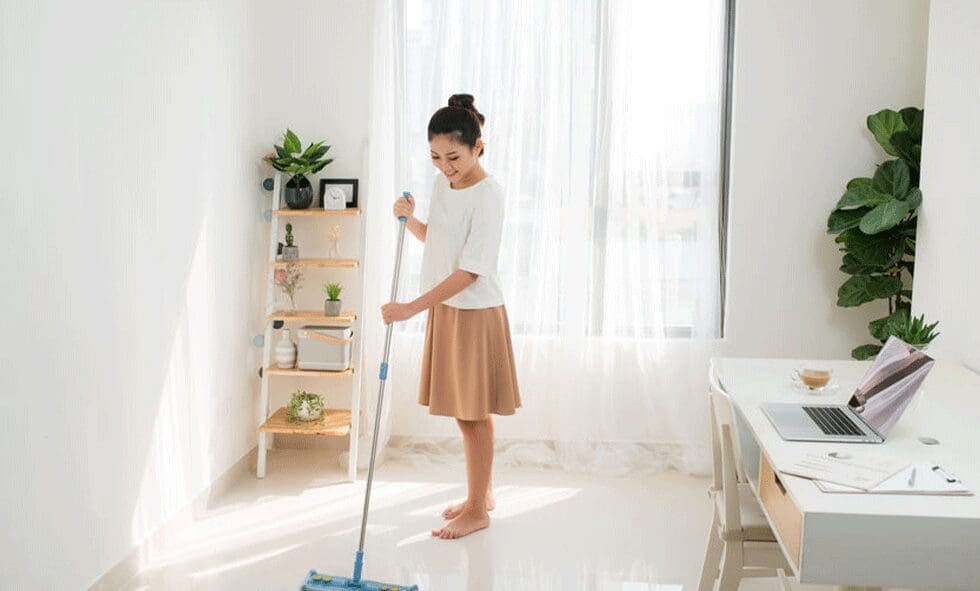 A woman is mopping the floor in her home.