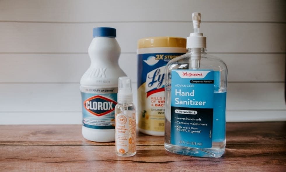 A table with cleaning supplies and hand sanitizer.