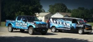 Two vans with a team logo on them parked in front of houses.