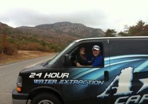 Two people waving from a service van.