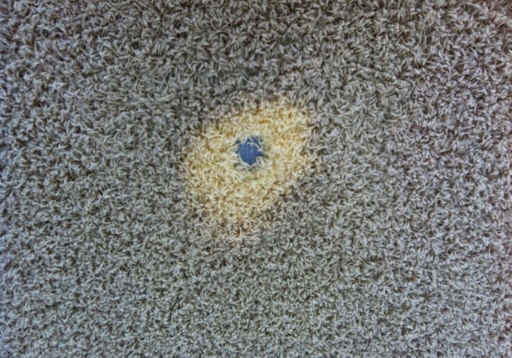 A carpet with a hole in it that is yellow and blue.