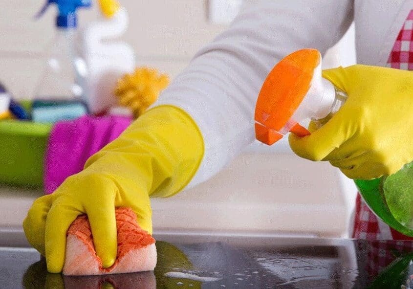 Person cleaning a surface with a sponge.