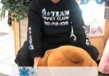 Person sitting on large stuffed animal.