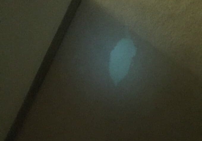 Faint light spot on carpeted floor.